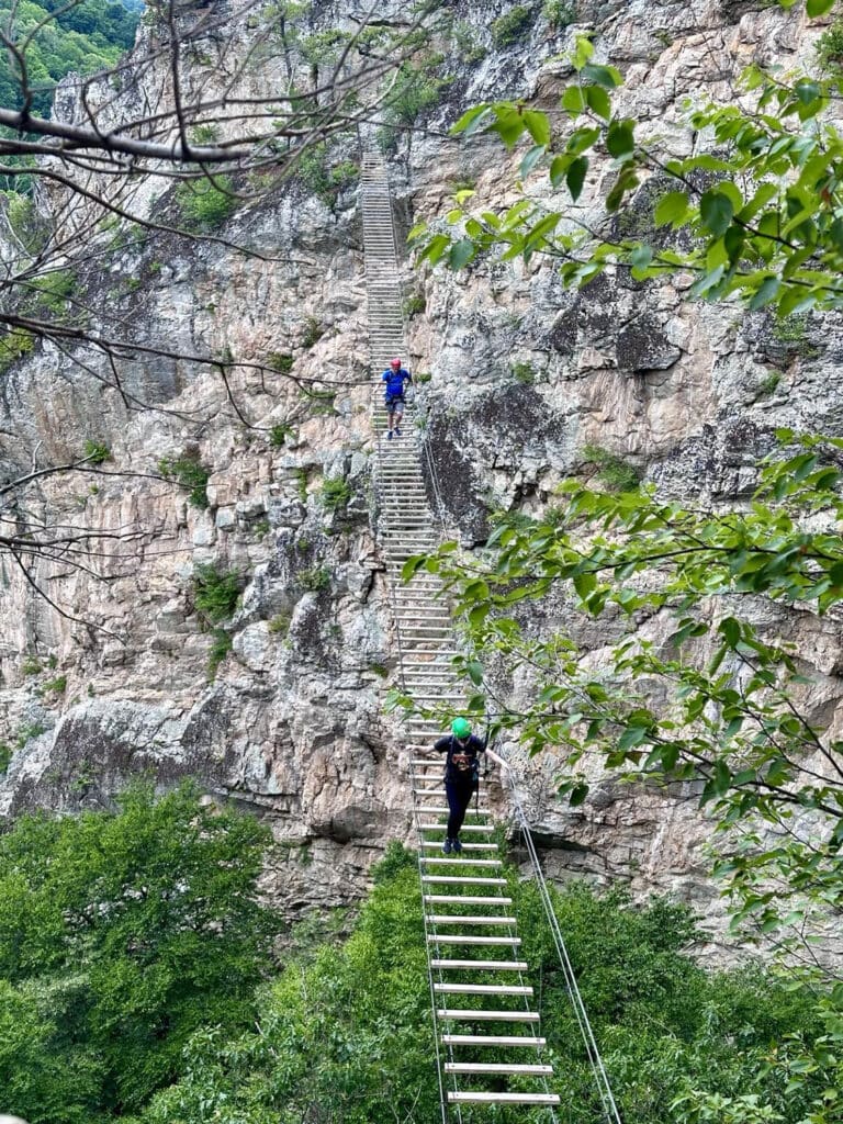 Two hikers crossing the 200 ft. long and 150 ft. high suspension bridge at NRocks 