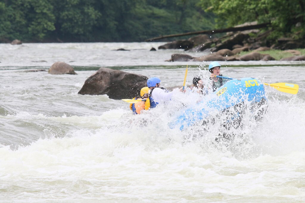 Action shot of family whitewater rafting in New River Gorge, West Virginia