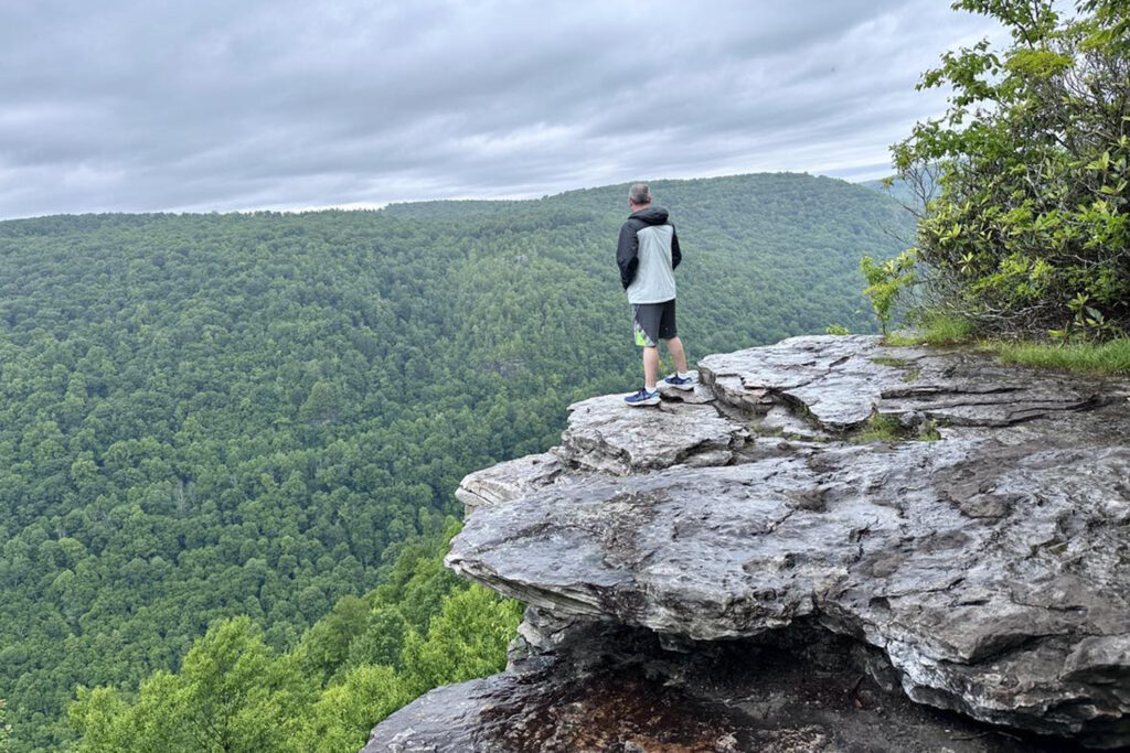 Man standing on large rock taking in the views of Lindy Point in Blackwater Falls WV